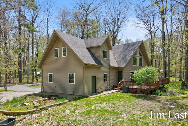 rear view of property with a deck, a shingled roof, and central AC unit
