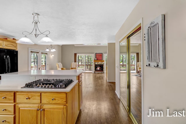 kitchen with gas stovetop, light countertops, black fridge, dark wood-style floors, and french doors