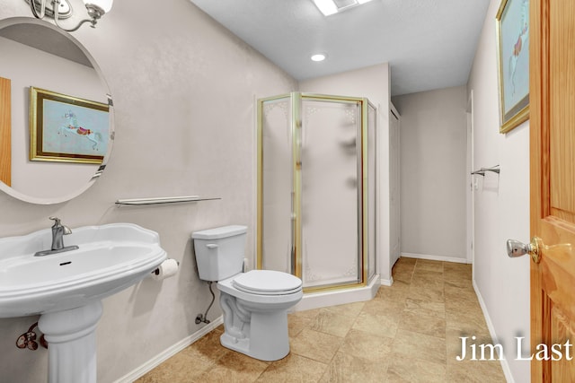 bathroom with toilet, a stall shower, baseboards, and recessed lighting