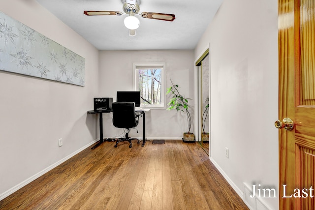 home office with wood finished floors, a ceiling fan, and baseboards
