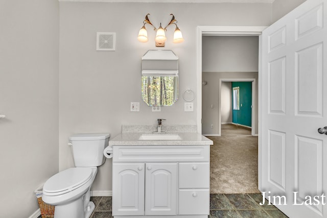 bathroom featuring toilet, vanity, and baseboards