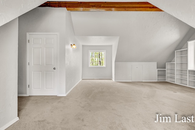 bonus room featuring vaulted ceiling, carpet flooring, and baseboards