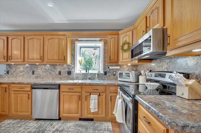 kitchen featuring stainless steel appliances, a sink, and tasteful backsplash