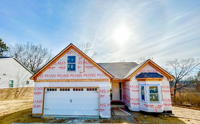 property in mid-construction featuring a shingled roof and a garage