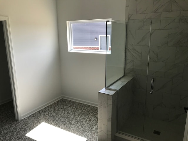 bathroom featuring a stall shower and baseboards
