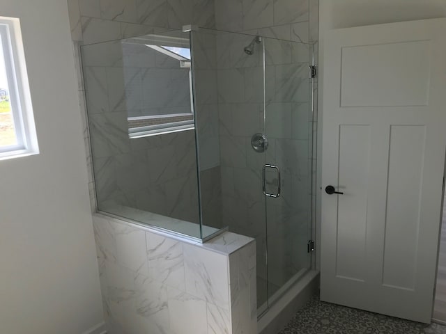 bathroom featuring a marble finish shower