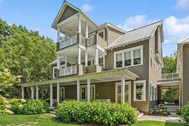 rear view of property with a balcony and a porch