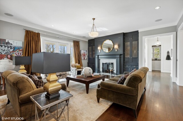 living area with healthy amount of natural light, ornamental molding, wood finished floors, and recessed lighting