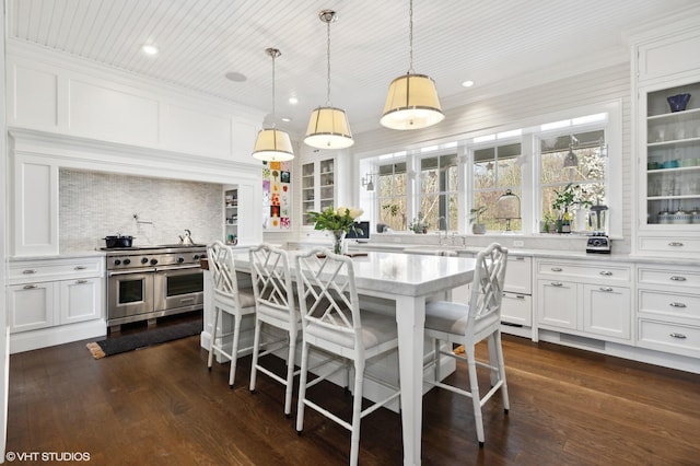 kitchen with range with two ovens, recessed lighting, glass insert cabinets, white cabinets, and backsplash