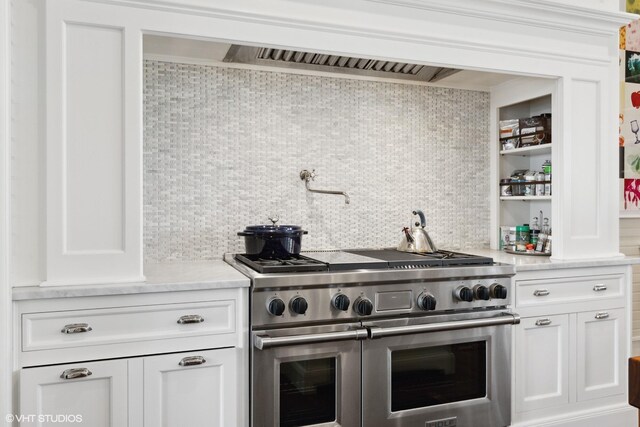 kitchen with double oven range, decorative backsplash, and light countertops