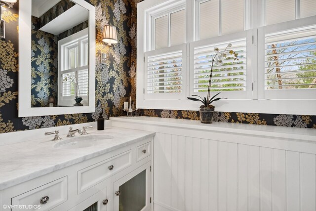 bathroom featuring wallpapered walls, healthy amount of natural light, and vanity