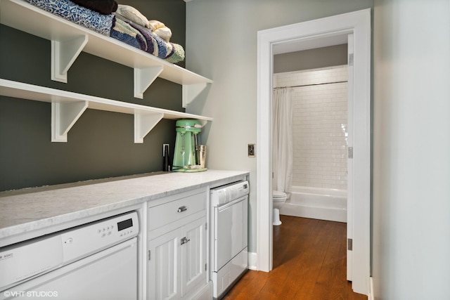 bar area featuring white dishwasher and dark wood-style flooring