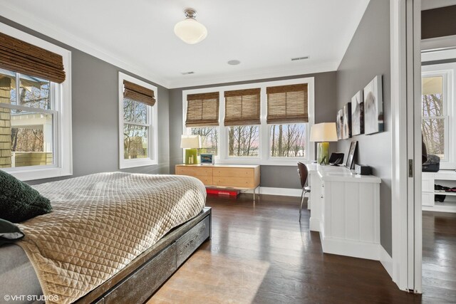 bedroom with dark wood-style flooring, baseboards, and crown molding