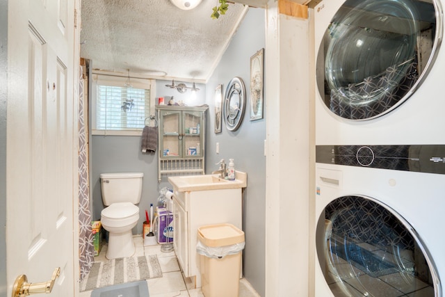 321 N Norman St, Barryton, MI 49305 - full bath featuring stacked washer and clothes dryer, toilet, tile patterned floors, a textured ceiling, and vanity