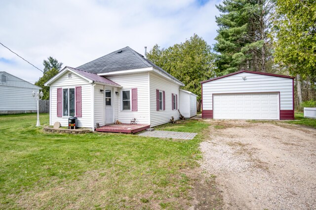 321 N Norman St, Barryton, MI 49305 - view of front of property with an outbuilding, a detached garage, a front lawn, and a wooden deck