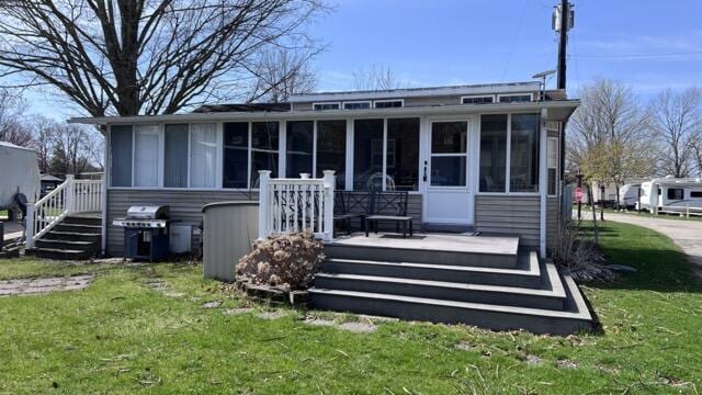 363 W Lake Street 106 &107, Sand Lake, MI 49343 - back of house featuring a sunroom, a lawn, and a deck