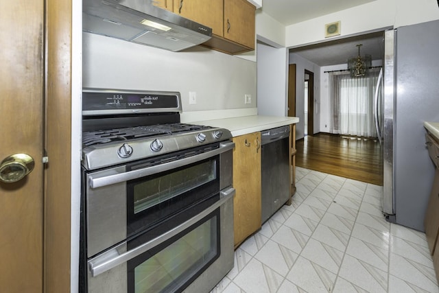 1620 Whittier Rd, Ypsilanti, MI 48197 - kitchen featuring appliances with stainless steel finishes, under cabinet range hood, brown cabinets, and light countertops
