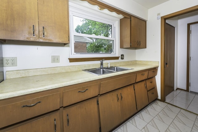 1620 Whittier Rd, Ypsilanti, MI 48197 - kitchen featuring a sink, light countertops, and brown cabinets