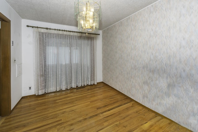 1620 Whittier Rd, Ypsilanti, MI 48197 - unfurnished dining area featuring wallpapered walls, wood finished floors, a chandelier, and baseboards