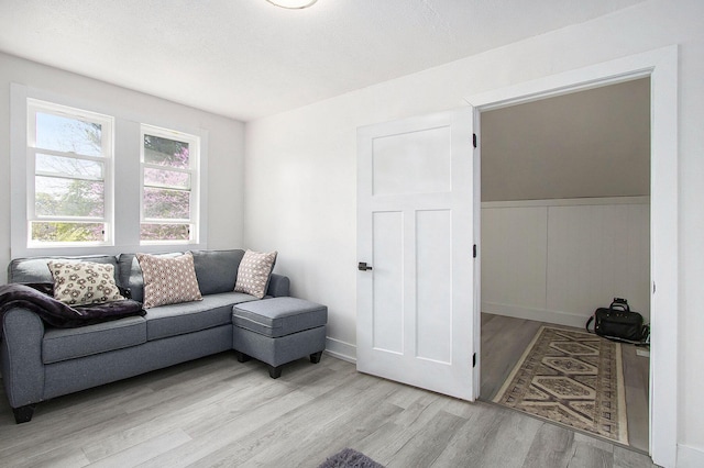 living room with light wood finished floors and wainscoting