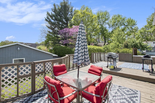 deck featuring outdoor dining area and grilling area