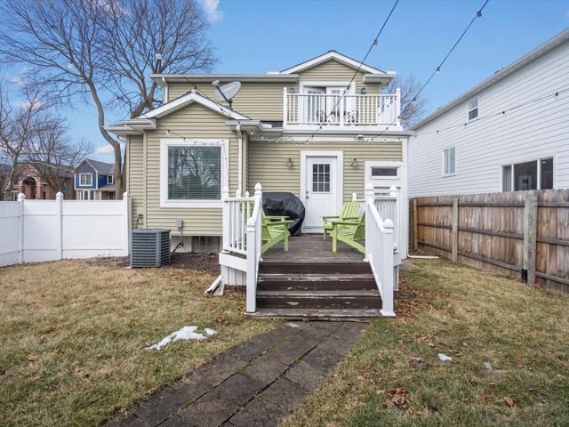 rear view of property featuring a wooden deck, a balcony, and central air condition unit