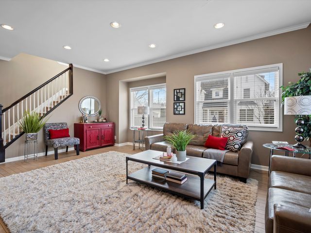 living area featuring ornamental molding, stairway, baseboards, recessed lighting, and wood finished floors