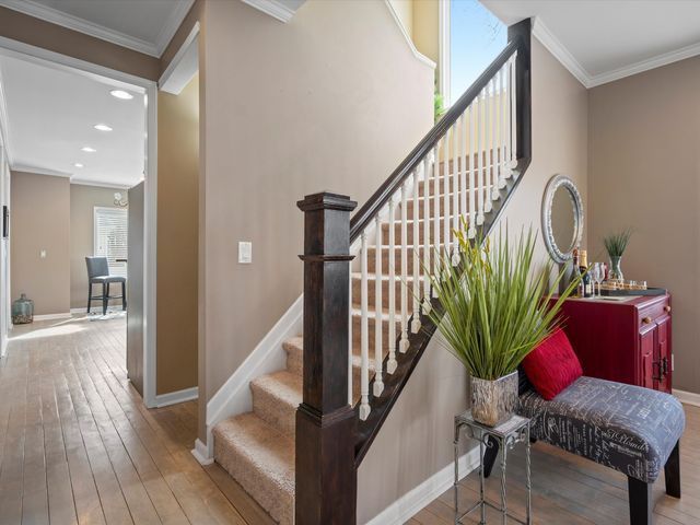 stairs with baseboards, hardwood / wood-style floors, crown molding, and recessed lighting