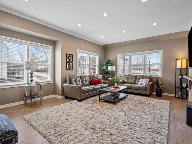 living area with crown molding, baseboards, wood finished floors, and recessed lighting