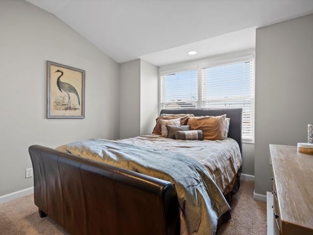 bedroom with carpet, baseboards, and lofted ceiling