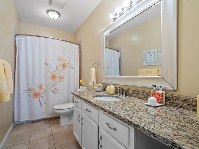 full bath featuring toilet, tile patterned floors, and vanity