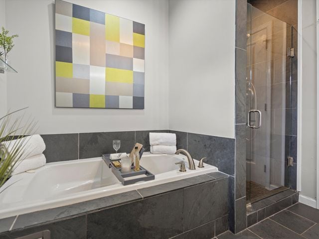 bathroom featuring a shower stall, a garden tub, and tile patterned flooring