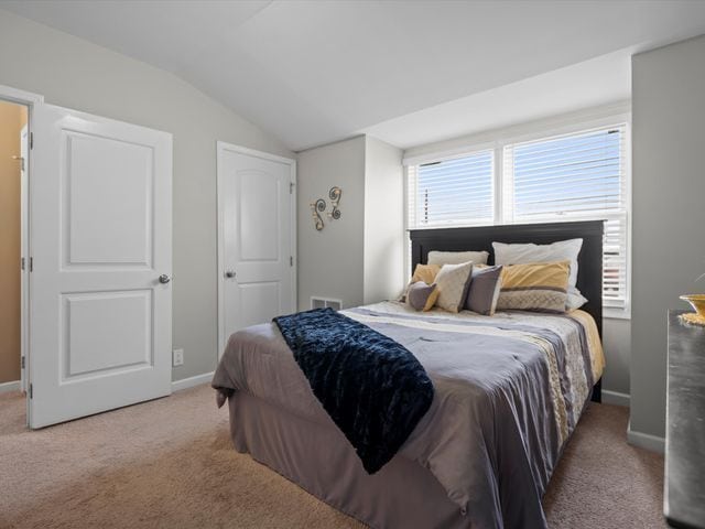 bedroom featuring vaulted ceiling, carpet flooring, and baseboards