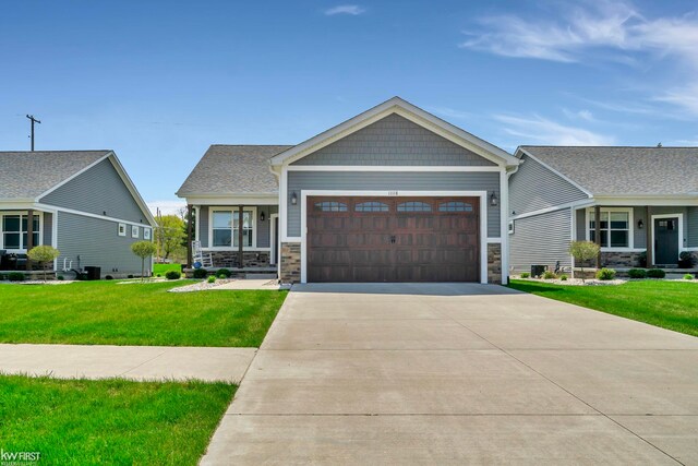 11146 Brahms Ln, Davison, MI 48423 - craftsman inspired home with a front yard, an attached garage, stone siding, and driveway