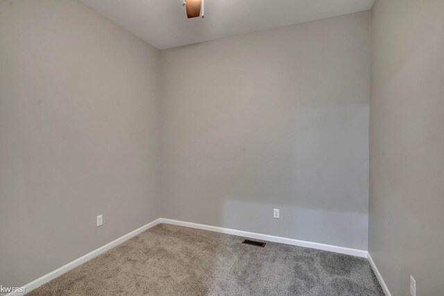 carpeted empty room featuring baseboards