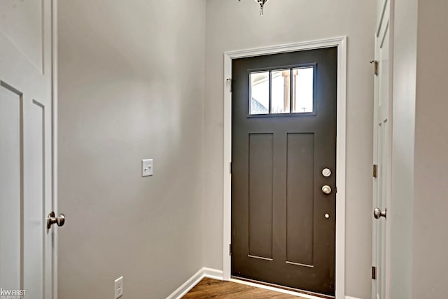 foyer featuring baseboards and wood finished floors
