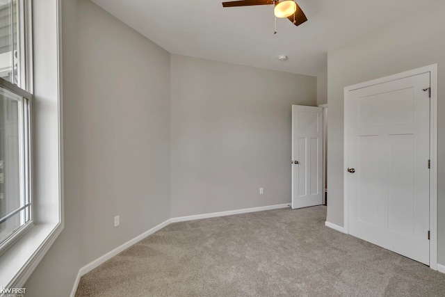 unfurnished bedroom with carpet, baseboards, and a ceiling fan