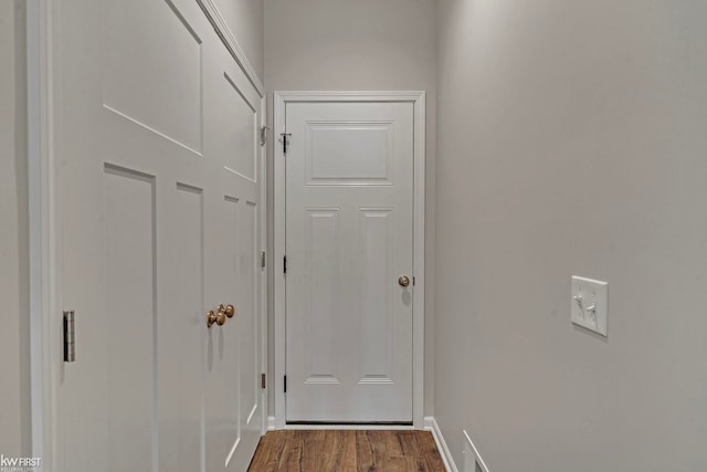 doorway featuring dark wood finished floors and baseboards