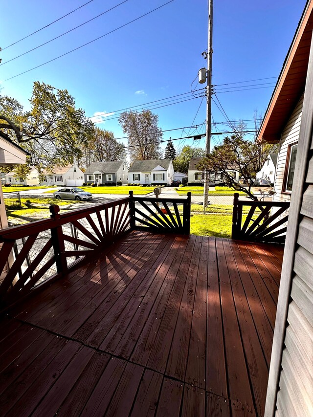 wooden terrace with a residential view and a lawn