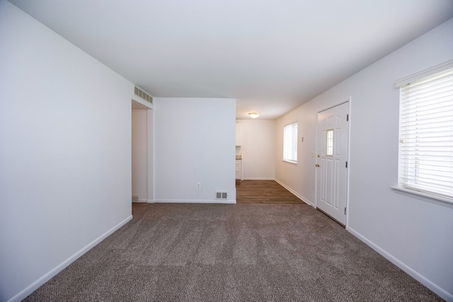 unfurnished room with carpet and baseboards