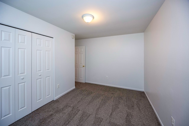 unfurnished bedroom featuring carpet floors, baseboards, and a closet