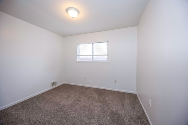 spare room featuring carpet floors and baseboards