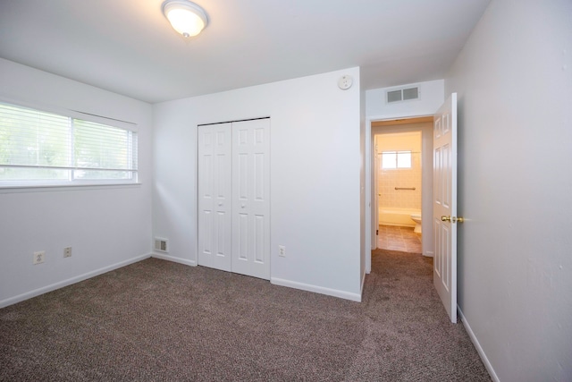 unfurnished bedroom with carpet flooring, a closet, and baseboards