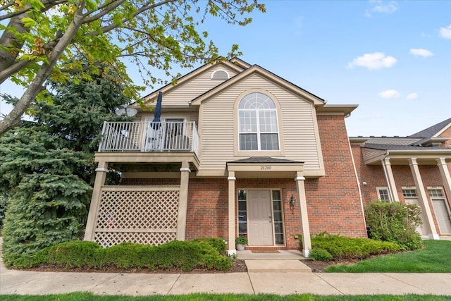 view of front of home with brick siding and a balcony
