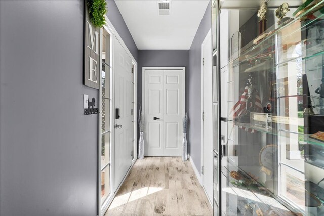 corridor featuring wood finished floors and baseboards