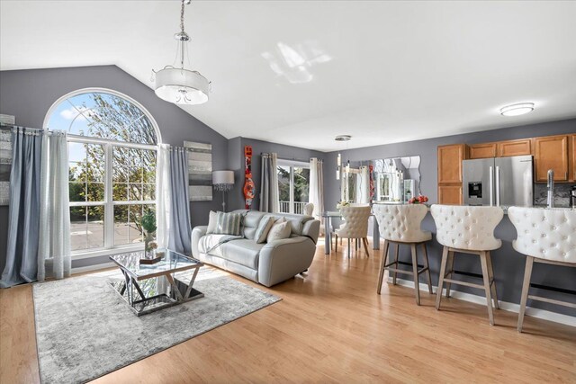 living room featuring vaulted ceiling and light wood-style floors