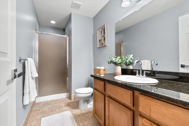 full bathroom featuring a stall shower, vanity, toilet, and baseboards