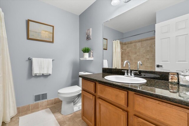 bathroom with tile patterned flooring, toilet, vanity, and curtained shower