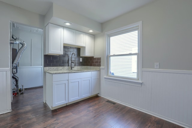 11067 Paige Ave, Warren, MI 48089 - kitchen with a sink, a wainscoted wall, white cabinetry, dark wood-style flooring, and light stone countertops