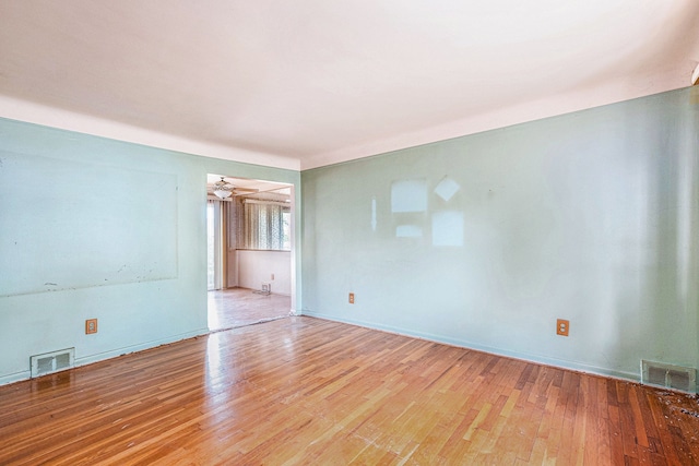 unfurnished room with wood finished floors, baseboards, and ceiling fan